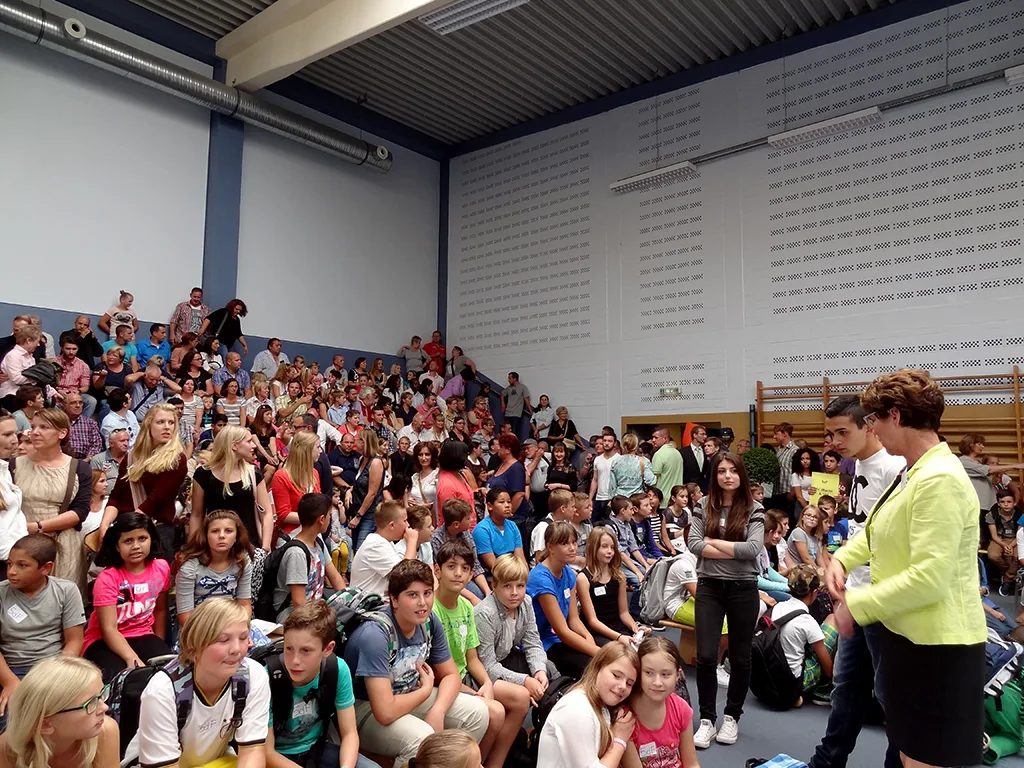 Kinder und Familien sitzen auf der Hallentribüne.